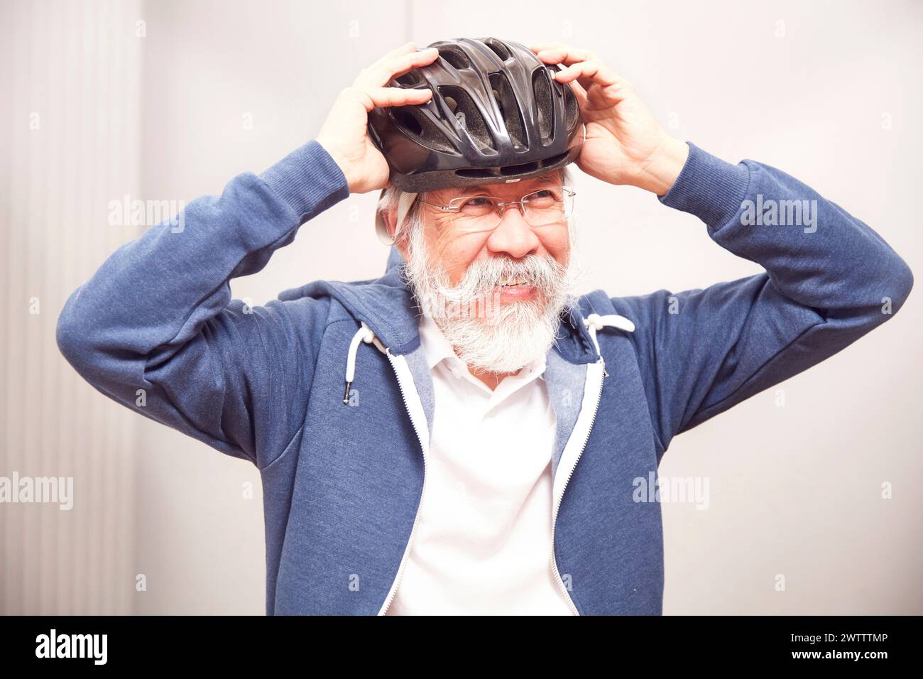 Senior Mann, der einen Fahrradhelm anpasst Stockfoto