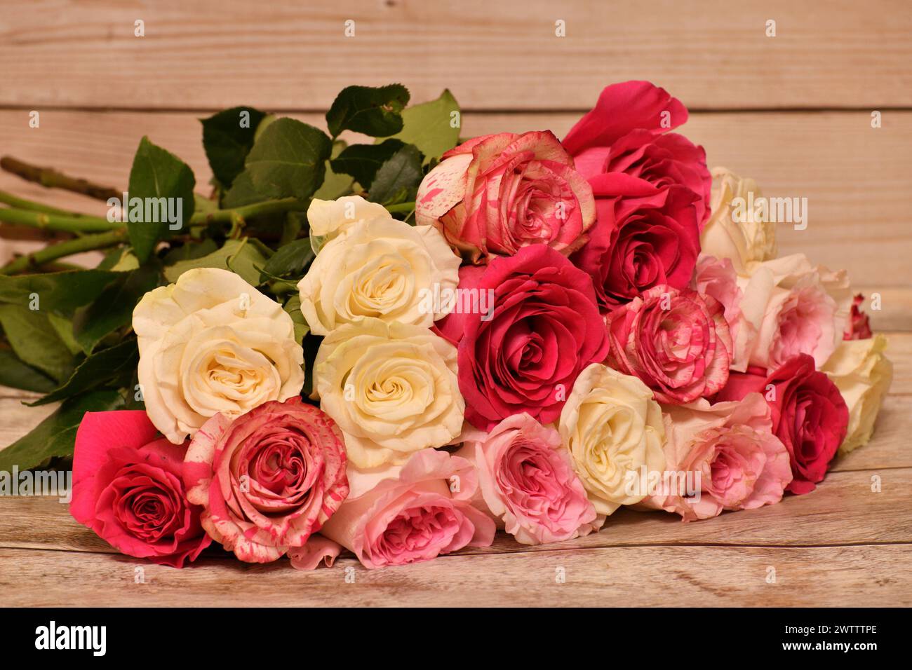 Auf dem Tisch liegt ein Strauß aus gelben und rosa Rosen Stockfoto