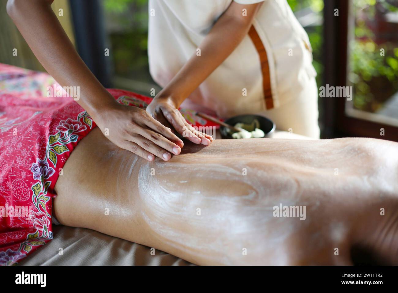 Massagetherapeut, der die Behandlung auf dem Rücken des Kunden anwendet Stockfoto