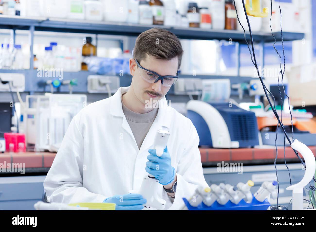 Wissenschaftler, der ein Reagenzglas im Labor untersucht. Stockfoto