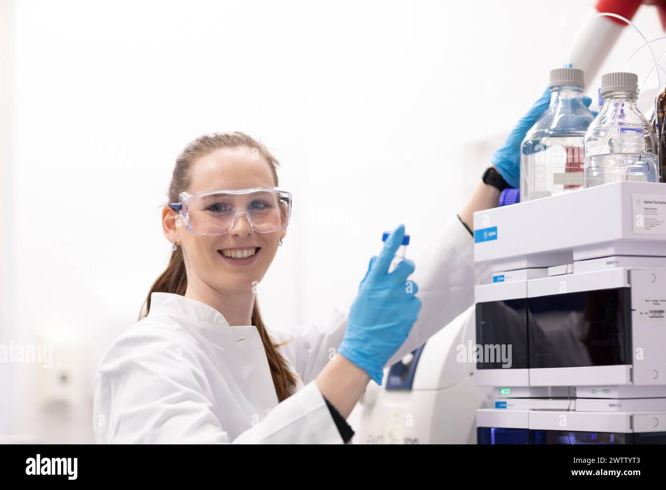 Lächelnde Wissenschaftlerin, die mit Laborgeräten arbeitet. Stockfoto