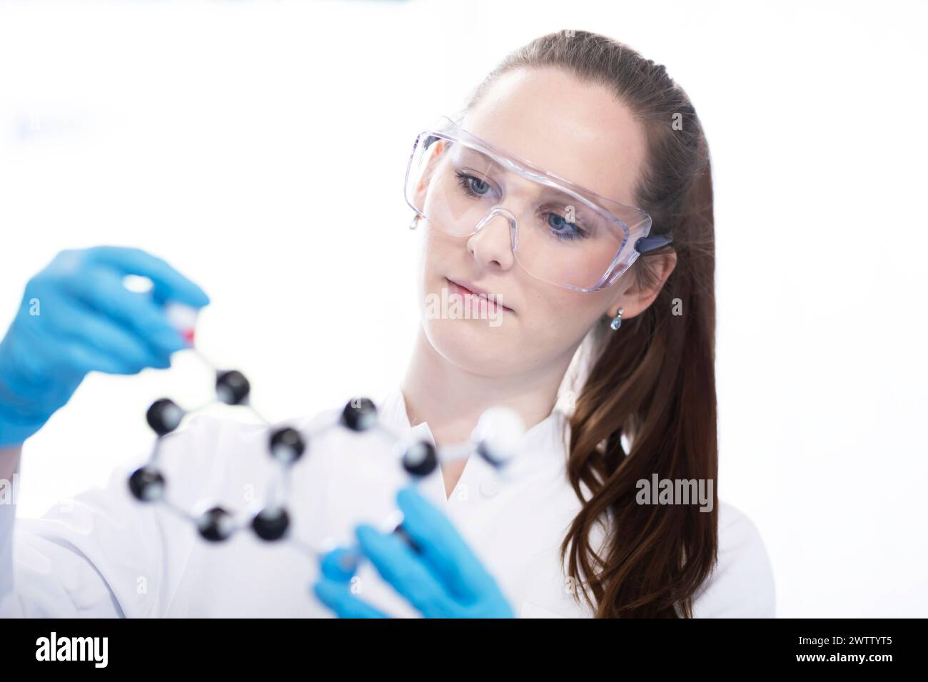 Fokussierter Wissenschaftler, der ein Molekularmodell im Labor untersucht Stockfoto