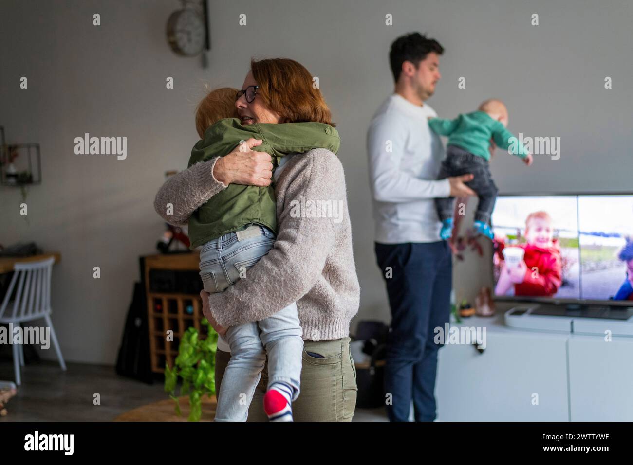 Familienzeit zu Hause mit Eltern, die ihre Kinder umarmen Stockfoto