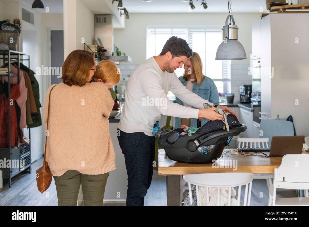 Familie, die ein Neugeborenes zu Hause begrüßt Stockfoto