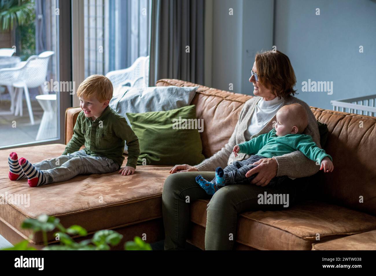Familienzeit auf der Couch mit Mutter und Kindern, die einen entspannten Tag zu Hause genießen Stockfoto