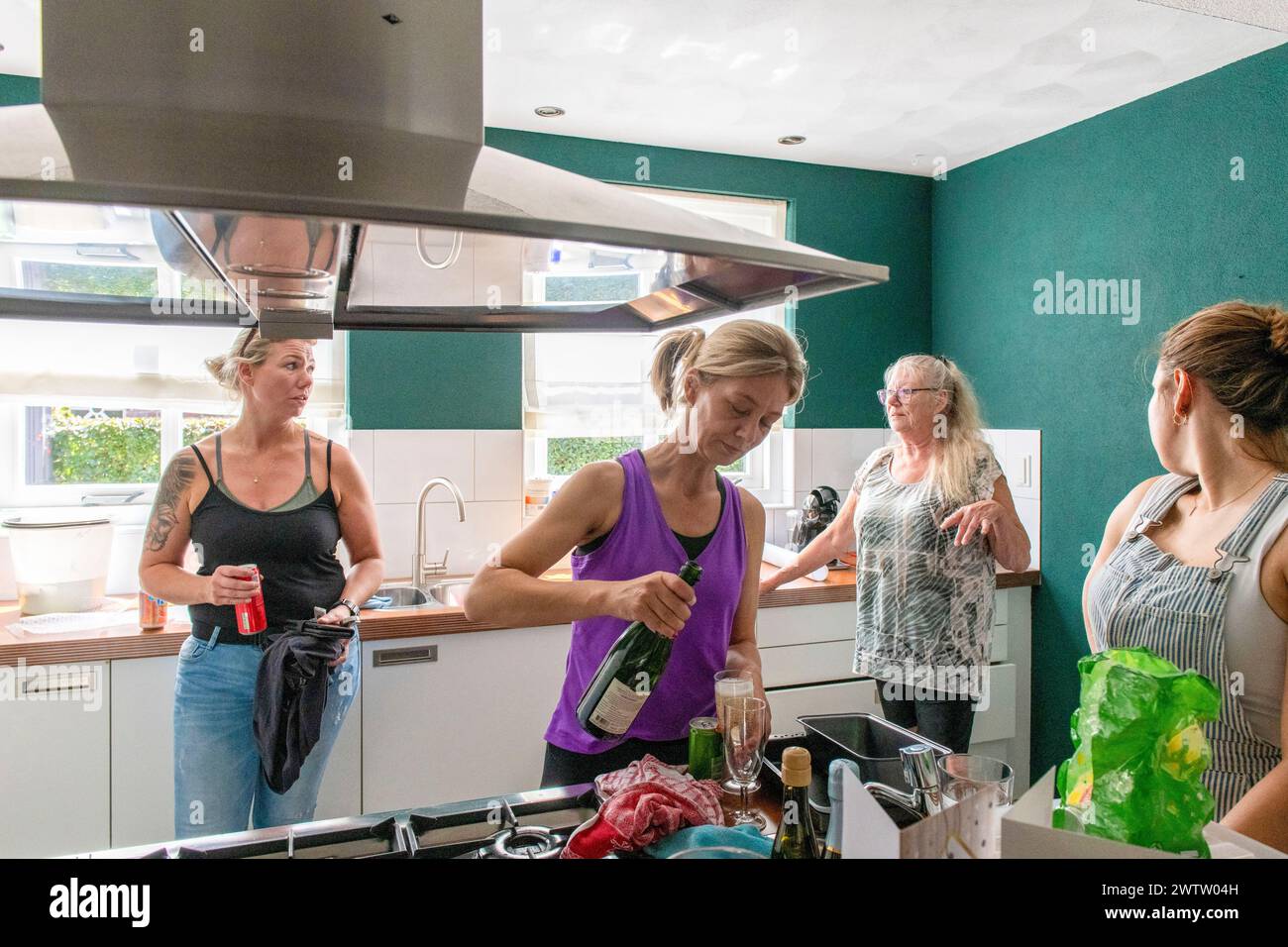 Familie und Freunde genießen die gemeinsame Zeit in gemütlicher Küche. Stockfoto