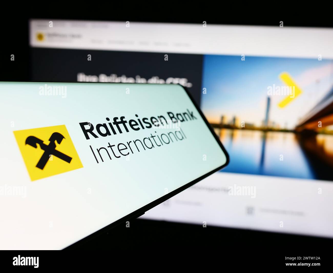 Smartphone mit Logo der österreichischen Raiffeisen Bank International AG (RBI) vor der Website. Fokussieren Sie sich auf die linke Mitte des Telefondisplays. Stockfoto