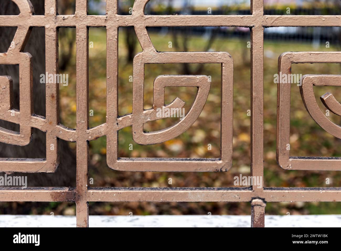 Vintage geschmiedetes Zaungitter in Goldfarbe mit geometrischem Muster bemalt, Nahaufnahme Außenfoto mit selektivem Fokus Stockfoto
