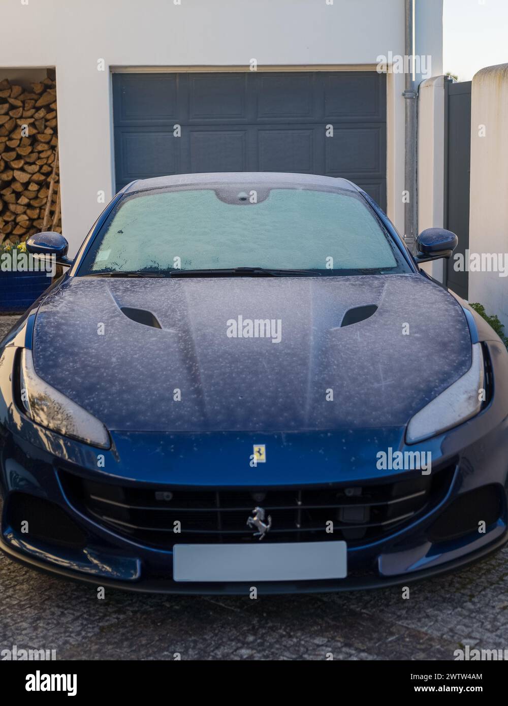 Bordeaux, 28. Februar 2023. Blauer Ferrari parkte an einem eisigen Tag vor einer Garage. Auf der Motorhaube sind Frostspuren sichtbar. Stockfoto