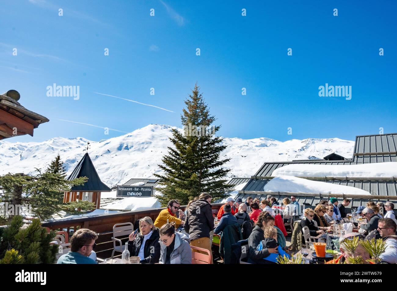 Les Menuires, Frankreich, Kaukasier auf einer Terrasse des Skigebietes in den französischen alpen, nur Editorial. Stockfoto