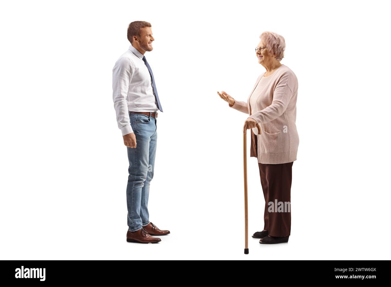 Ältere Frau, die mit einem Mann in Jeans und weißem Hemd spricht, isoliert auf weißem Hintergrund Stockfoto