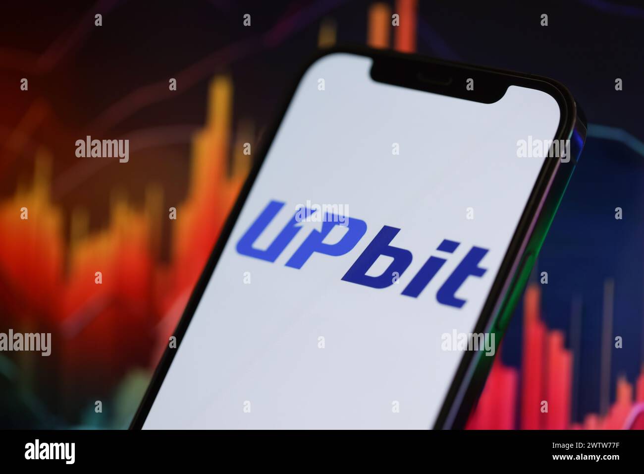 KIEW, UKRAINE - 15. MÄRZ 2024 Upbit-Logo auf dem iPhone-Display und Kryptowährungswertdiagrammen. Portal für den Austausch von Kryptowährungen Stockfoto