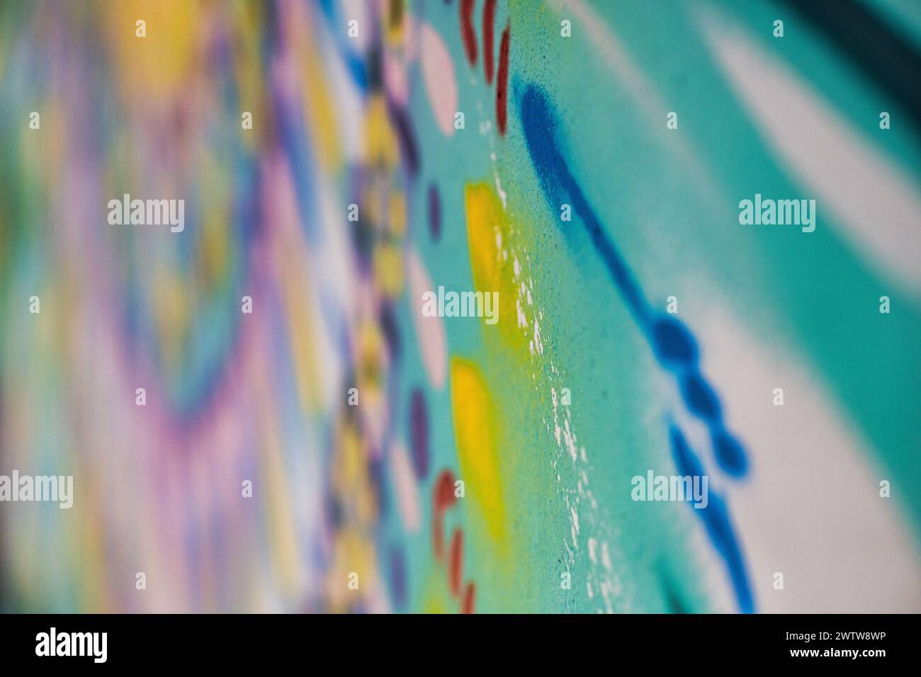 Ein detailliertes Foto, das die lebendigen Farben und Texturen von gesprühten Graffiti an einer Wand festlegt Stockfoto