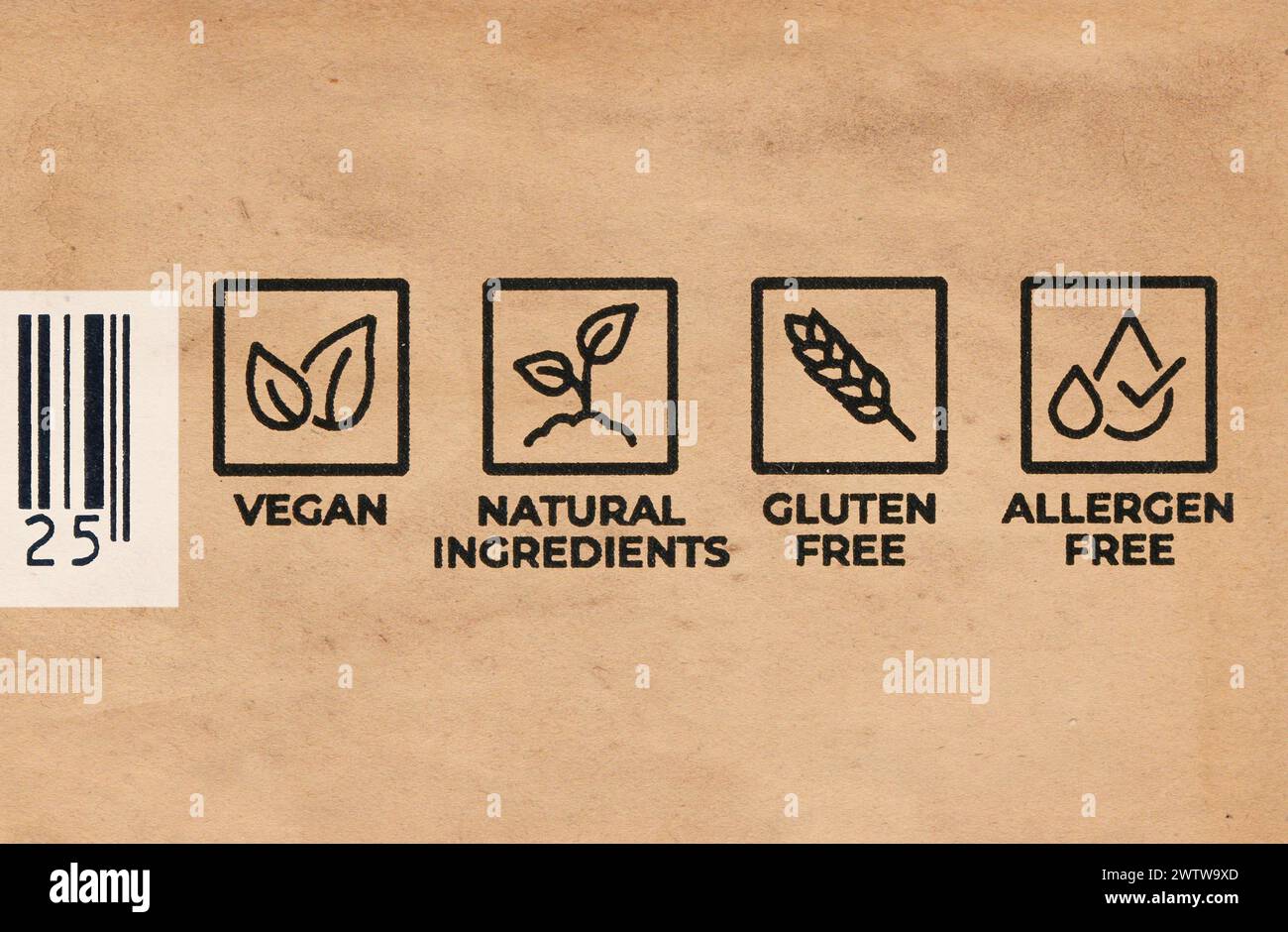 Etiketten auf einer Lebensmittelverpackung mit der Aufschrift Vegan, natürliche Inhaltsstoffe Glutenfrei Allergenfrei mit einem Teil eines Strichcodes. Nahaufnahme auf braunem Papier. Kopenhagen Stockfoto