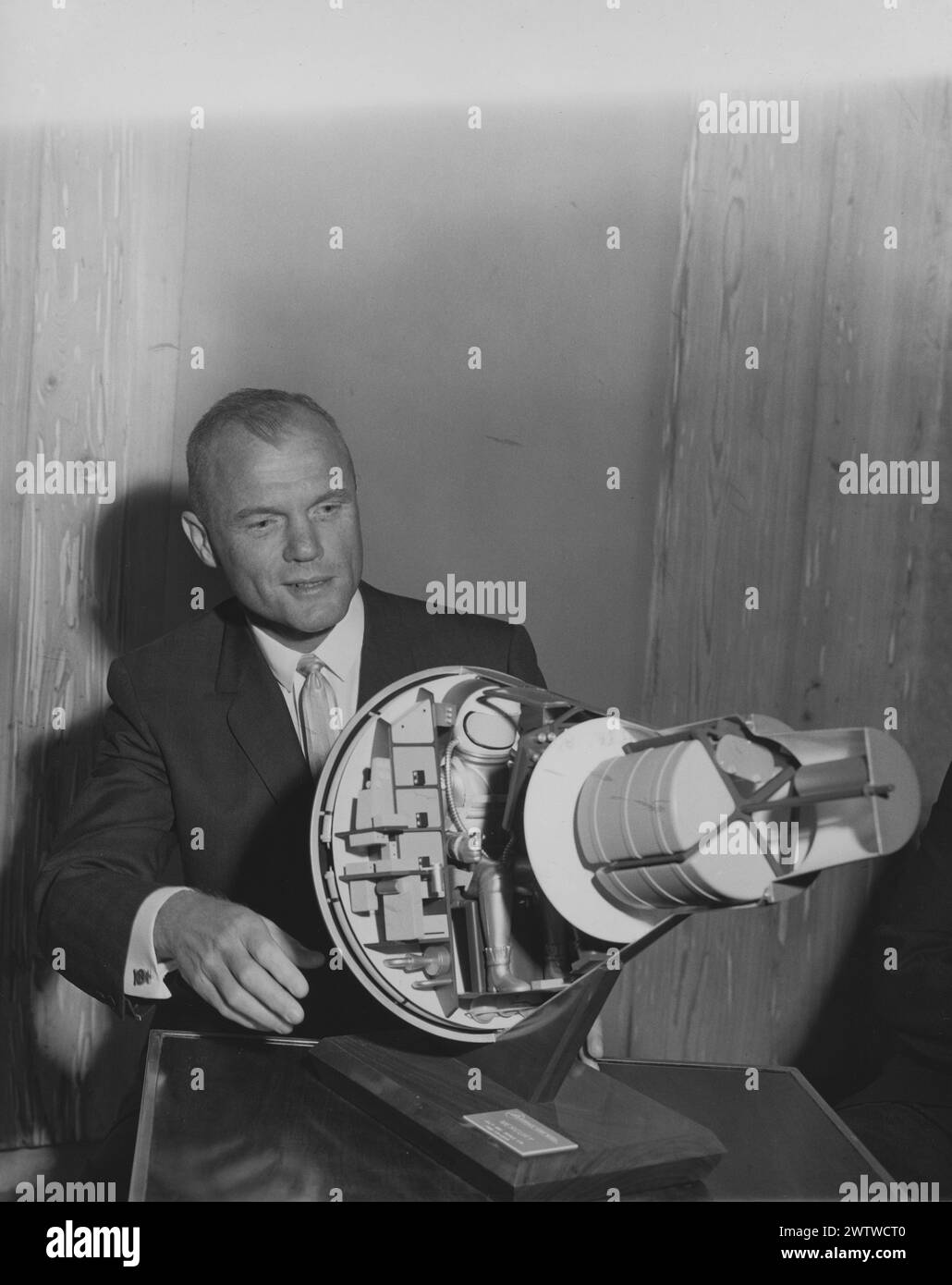 US-Astronaut John Glenn sitzt an einem Tisch mit einem Modell der Raumkapsel, die er auf der Umlaufbahn der Erde fliegen wird Stockfoto