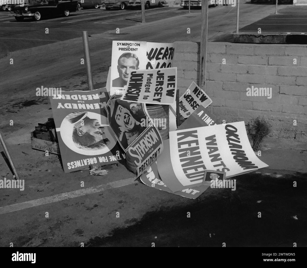 Ein Stapel von Kampagnenplakaten, die 1959 auf einem Parkplatz standen. John F. Kennedy, Symington, Stephenson, Johnson auf den Plakaten Stockfoto