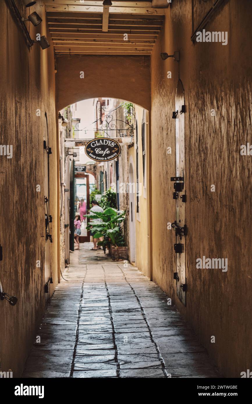 Eine malerische Gasse führt zu einem gemütlichen Restaurant mit warmer Beleuchtung und einem einladenden Schild am Ende Stockfoto