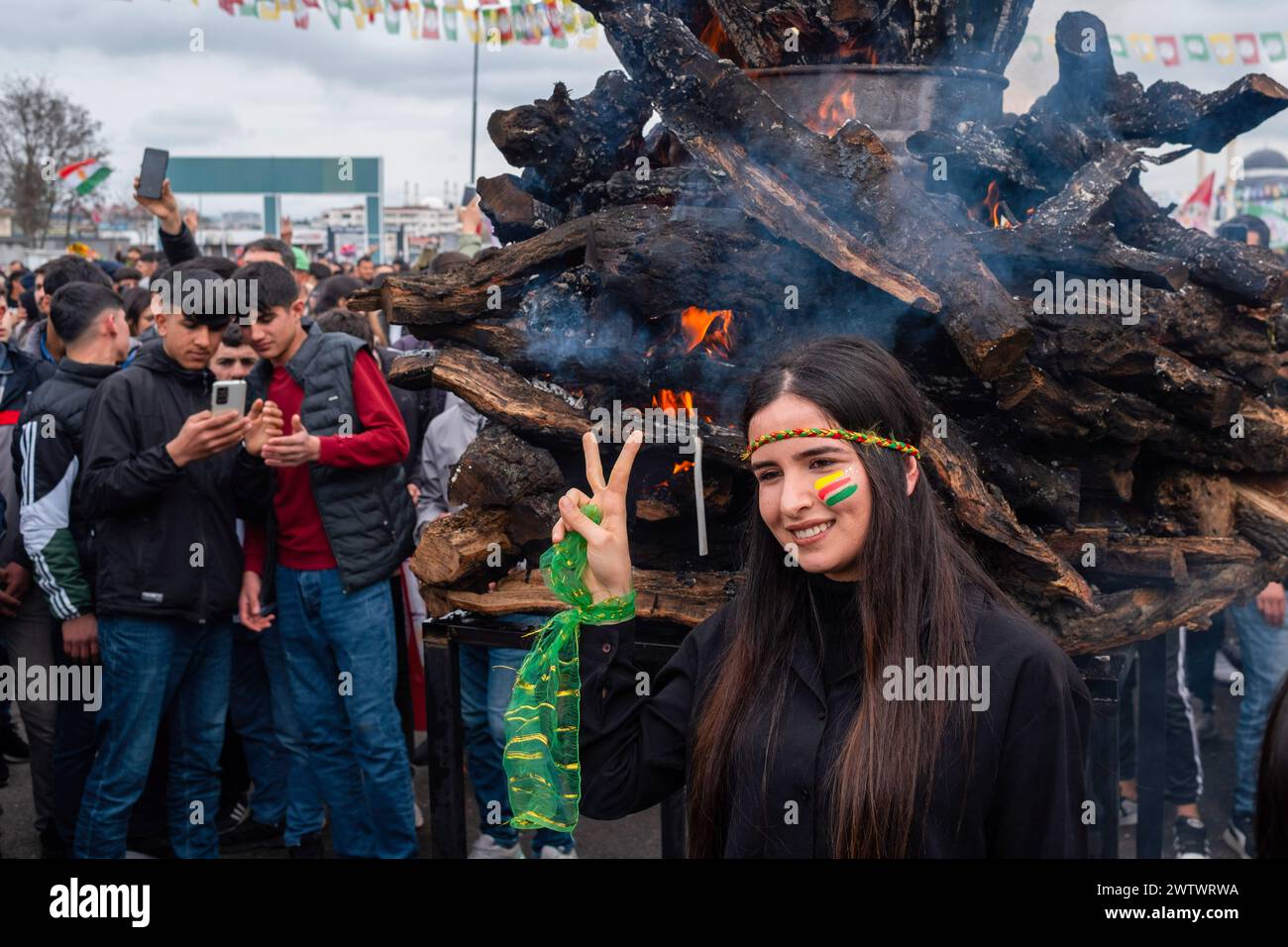 Batman, Türkei. März 2024. Eine junge Frau macht Fotos vor dem Newroz-Feuer. Zehntausende von Menschen versammelten sich in Batman, um das neue Jahr und den Frühling mit großer Begeisterung und ihren farbenfrohen Kostümen zu feiern. Quelle: SOPA Images Limited/Alamy Live News Stockfoto