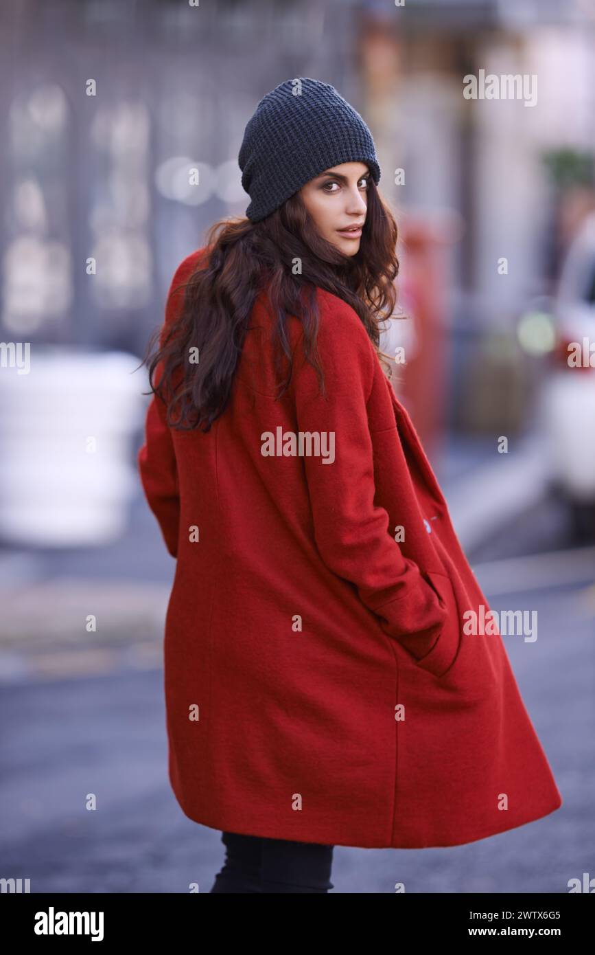 Winter, Mode und Porträt einer Frau in der Stadt mit Jacke für Reisen in coolem Stil oder rotem Mantel. Streetwear, Kleidung und Mädchen gehen selbstbewusst Stockfoto
