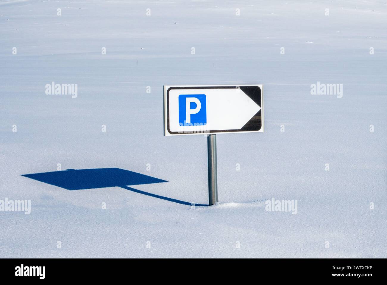 Ein Straßenschild, das aus tiefem Schnee auf einer unter Schnee vergrabenen Straße in Norwegen ragt Stockfoto