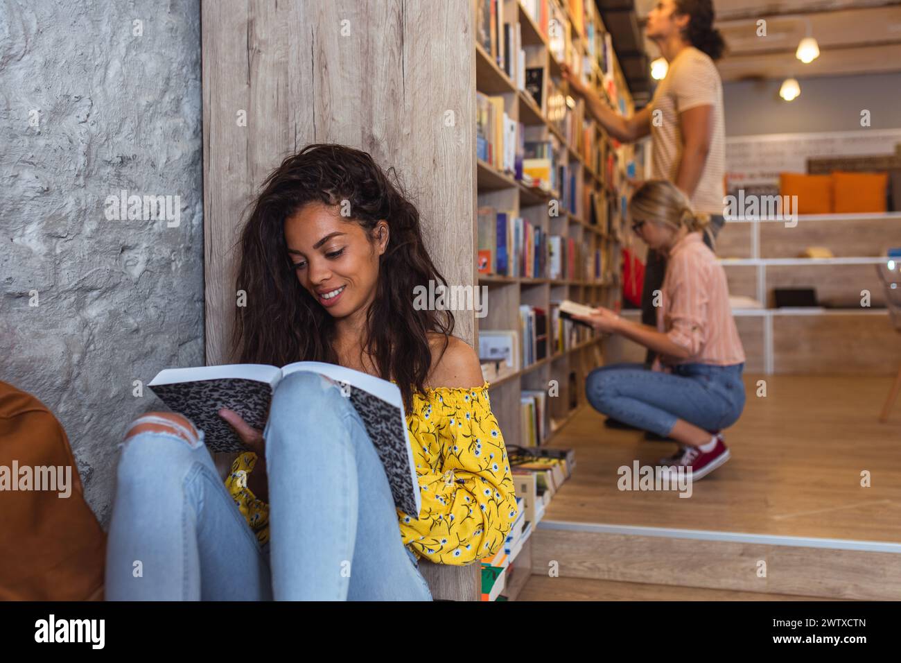Junge Studentinnen studieren im Bibliothekslesebuch. Stockfoto