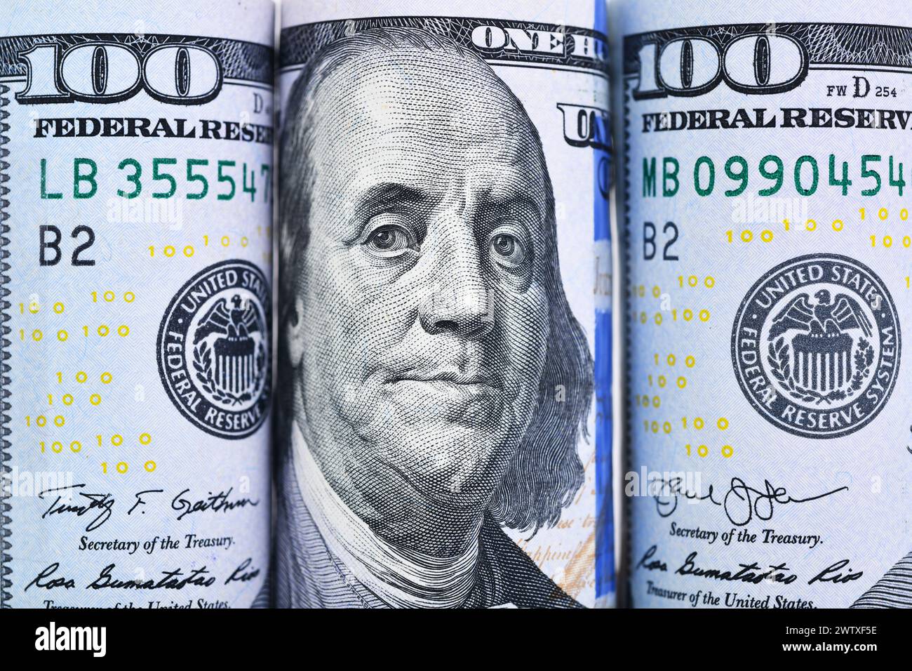 Nahaufnahme vieler Rolls 100 US-Dollar-Banknoten auf weißem Hintergrund Stockfoto