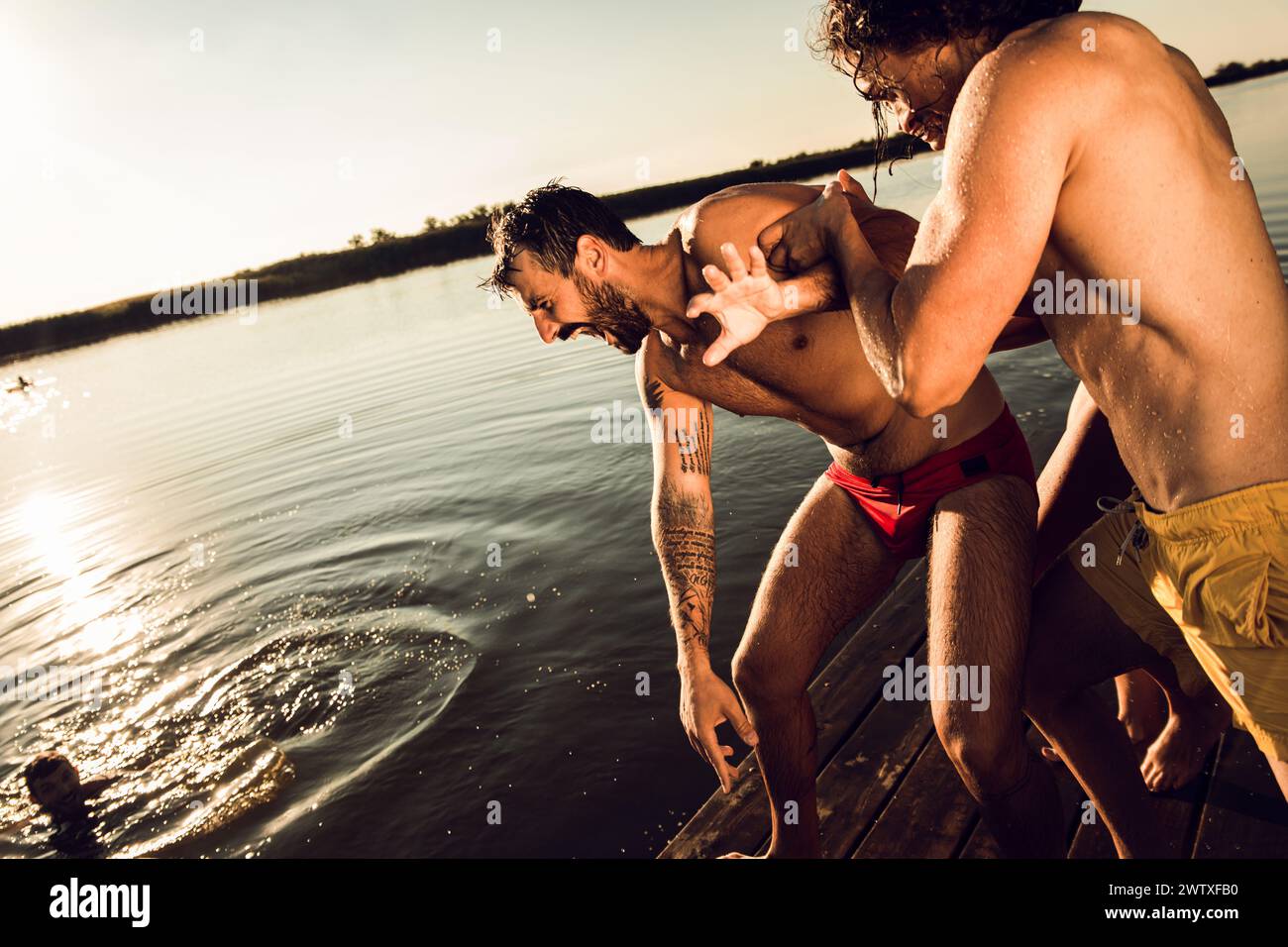 Eine Gruppe von Freunden, die Spaß haben, einen Sommertag mit Schwimmen und Springen auf dem See zu genießen. Stockfoto