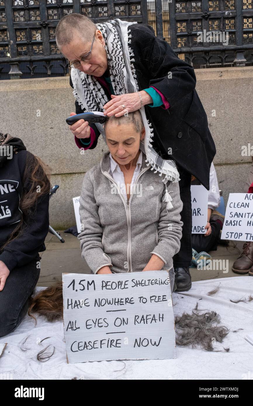 London, UK, 19. März 2024. Aktivistin rasiert sich vor den Parlamentsgebäuden den den Kopf, in Solidarität mit den Frauen von Gazza. Kredit: James Willoughby Stockfoto