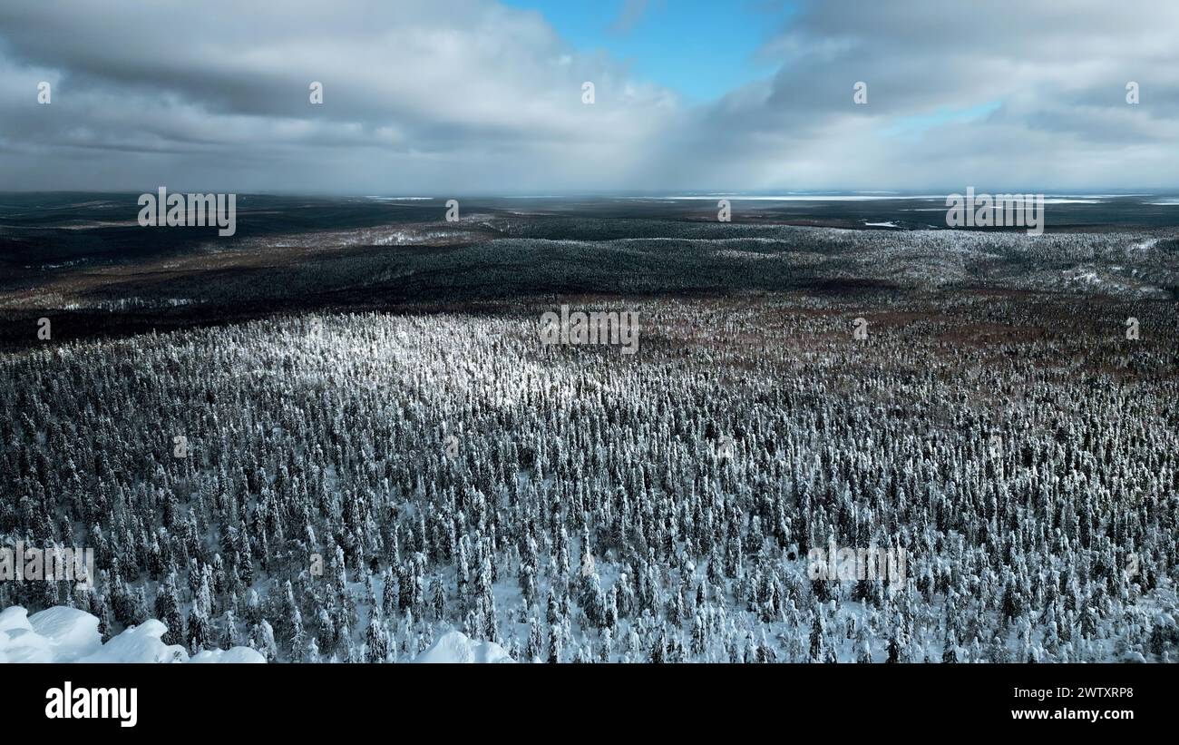 Ein Flug über den dichten sibirischen Winterwald am Nachmittag. Clip. Weißer Berg und ein gefrorener Wetterturm auf seiner Spitze. Stockfoto