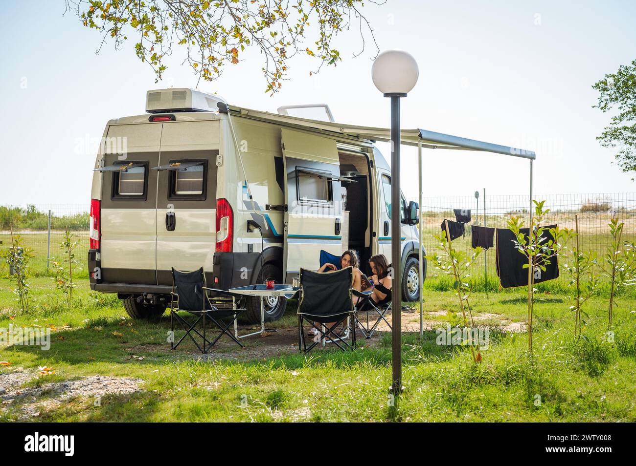 Familiencamping mit einem Wohnmobil auf Campingplätzen in Griechenland oder Kroatien. Familienentspannung mit Wohnmobil, Stühlen und Tisch im Urlaub. Stockfoto