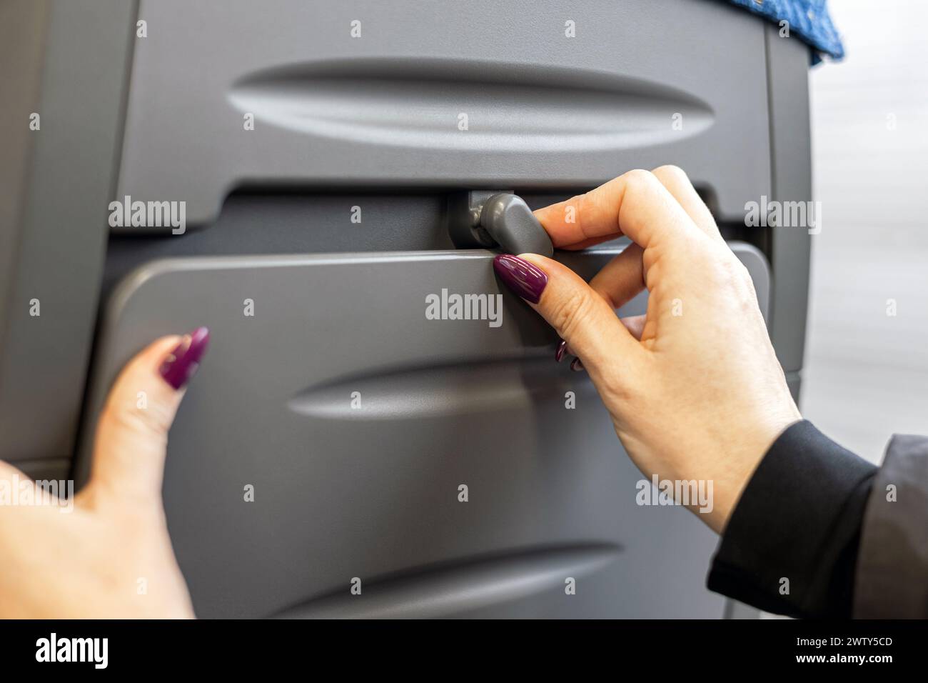 Frau mit Klapptisch im Zug, Nahaufnahme. Klapptisch auf der Rückseite des Stuhls. Klapptisch beim Transport Stockfoto