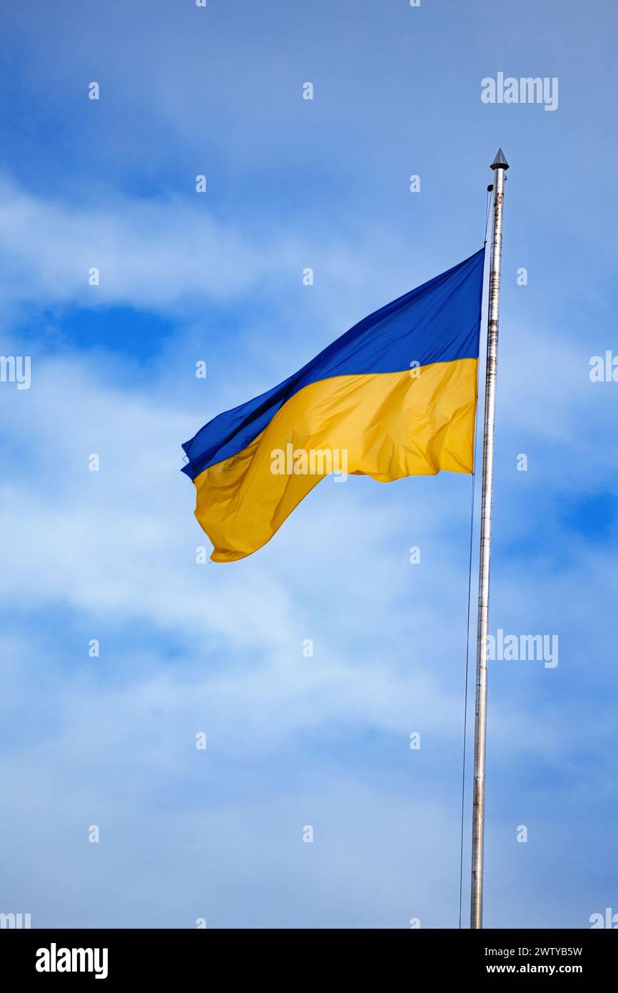 ukrainische Flagge vor dem blauen Himmel aus nächster Nähe. Nationalstolz und Symbol des Landes Ukraine. Krieg in der Ukraine. Gelb-blaue Flagge. Stockfoto