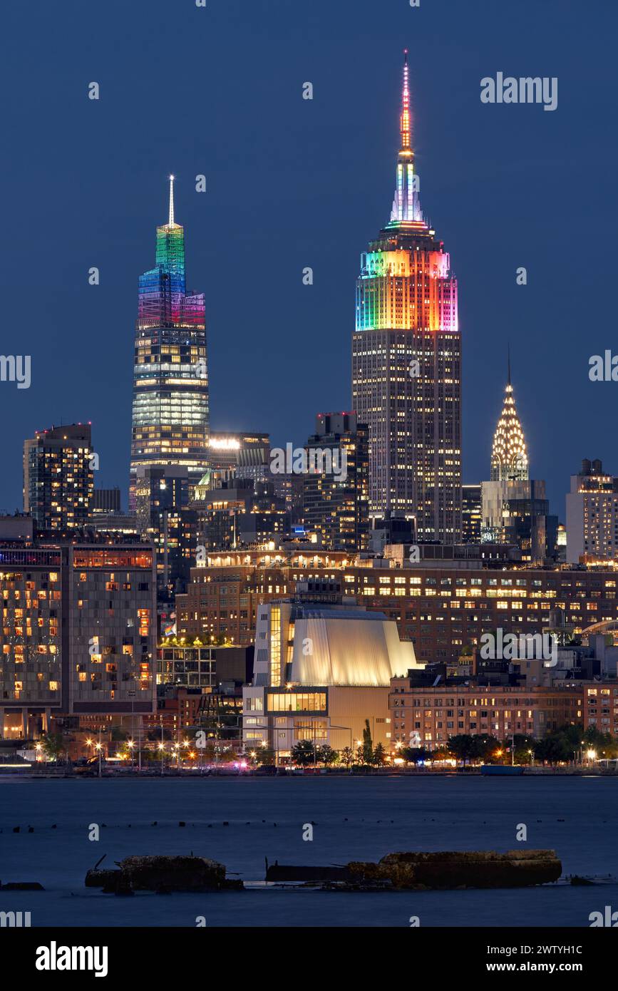 New York City: Das Empire State Building und ein in Regenbogenfarben beleuchtetes Venderbilt-Wolkenkratzer für die LGBTQ+ Gay Pride Week. Midtown, Manhattan Stockfoto