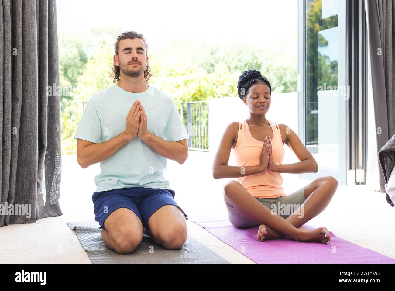 Ein vielseitiges Paar übt Yoga zusammen in einer ruhigen Umgebung Stockfoto