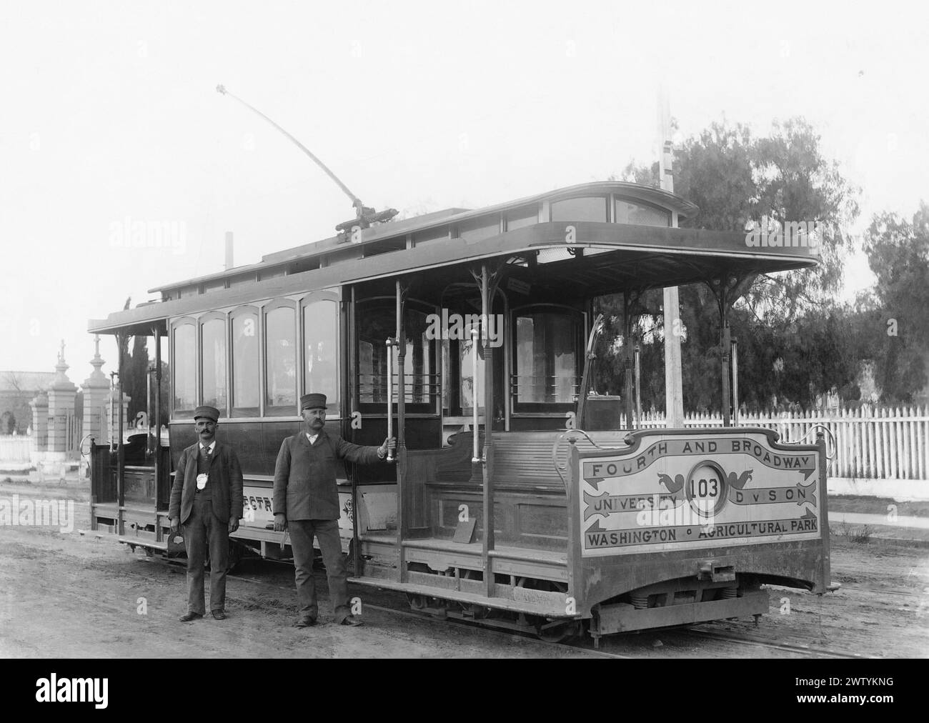 Zwei Arbeiter, wahrscheinlich Dirigenten, die sich vor einem einzigen Wagen namens 4th und Broadway ausgeben. Eine der ersten elektrischen Straßenbahnen in Los Angeles, ca. 1900 Stockfoto
