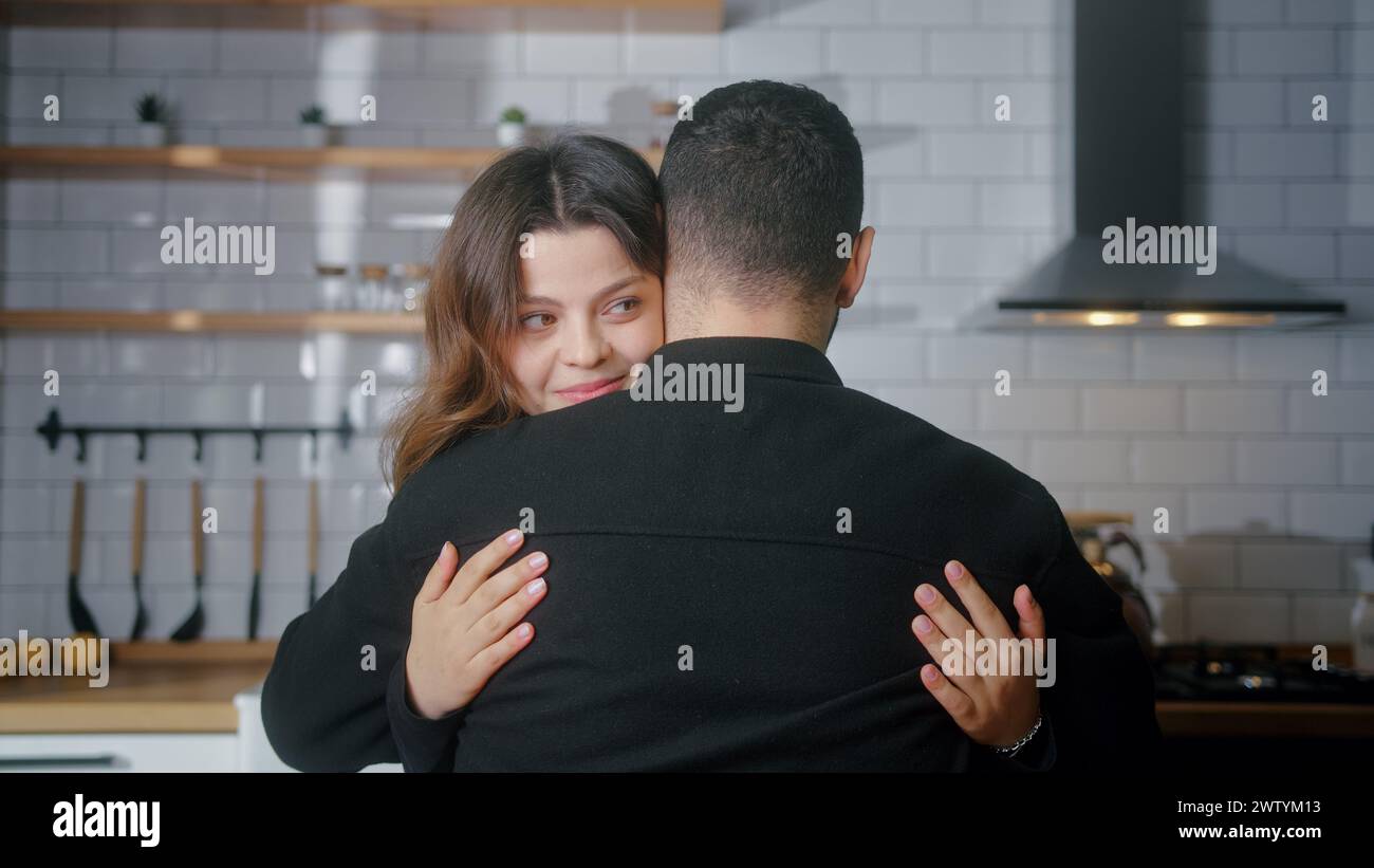 Rückansicht eines Mannes, der ihren Freund umarmt. Schöne Frau, die ihren Liebhaber in der Küche umarmt. Mittlere Nahaufnahme Kuscheln geliebtes Paar Stockfoto