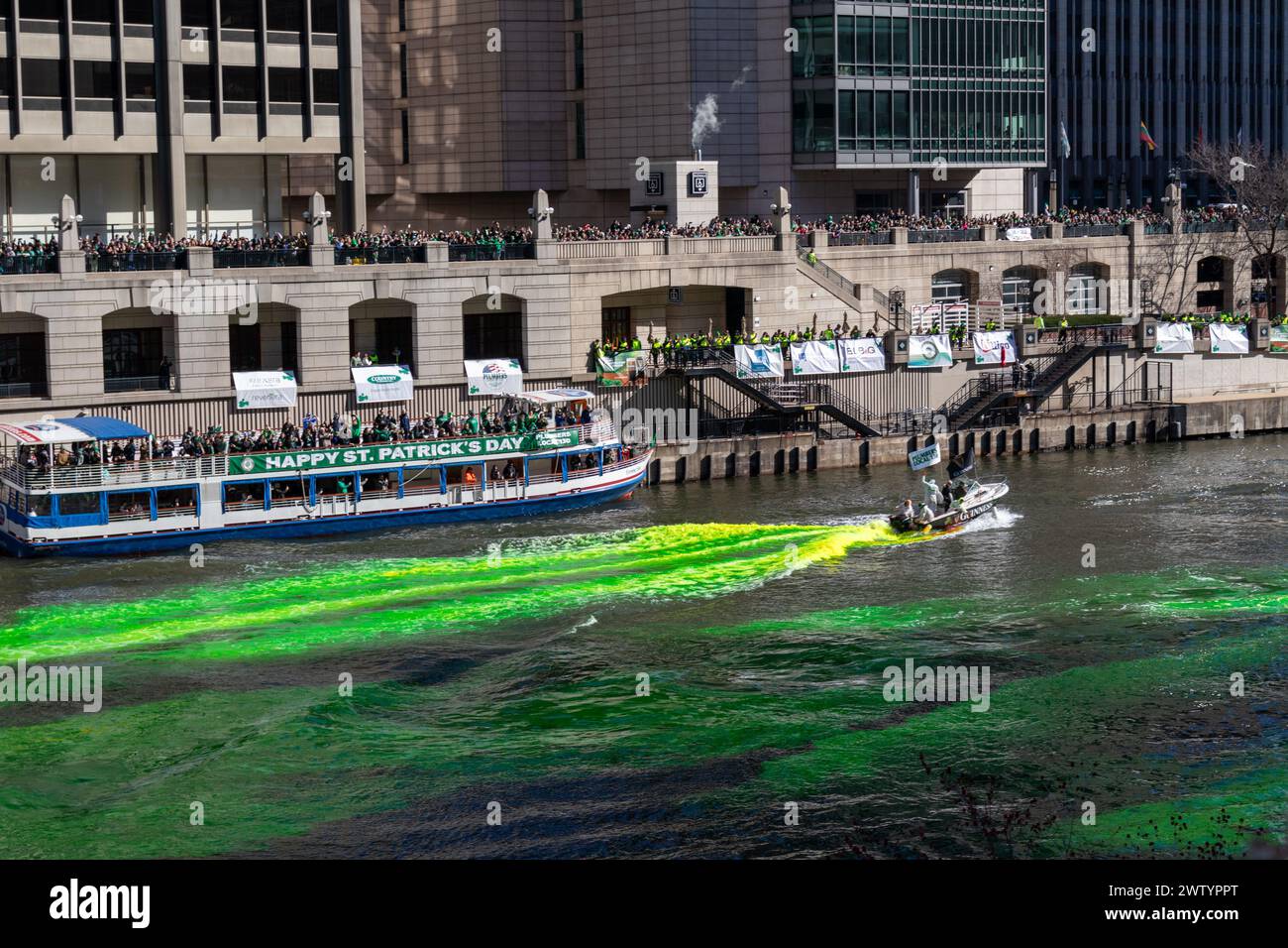 Menschenmassen beobachten, wie der Chicago River während der jährlichen Feierlichkeiten zum St. Patrick's Day grün gefärbt wird Stockfoto