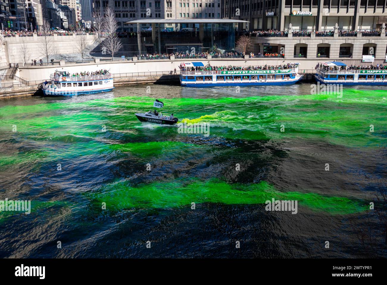 Menschenmassen beobachten, wie der Chicago River während der jährlichen Feierlichkeiten zum St. Patrick's Day grün gefärbt wird Stockfoto