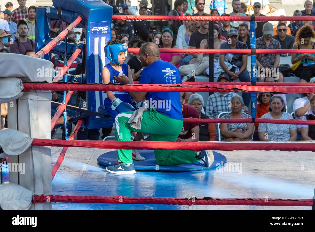 Oaxaca, Mexiko - Ein Trainer bereitet einen Jungen auf ein Jugendboxspiel im Zocalo vor. Stockfoto