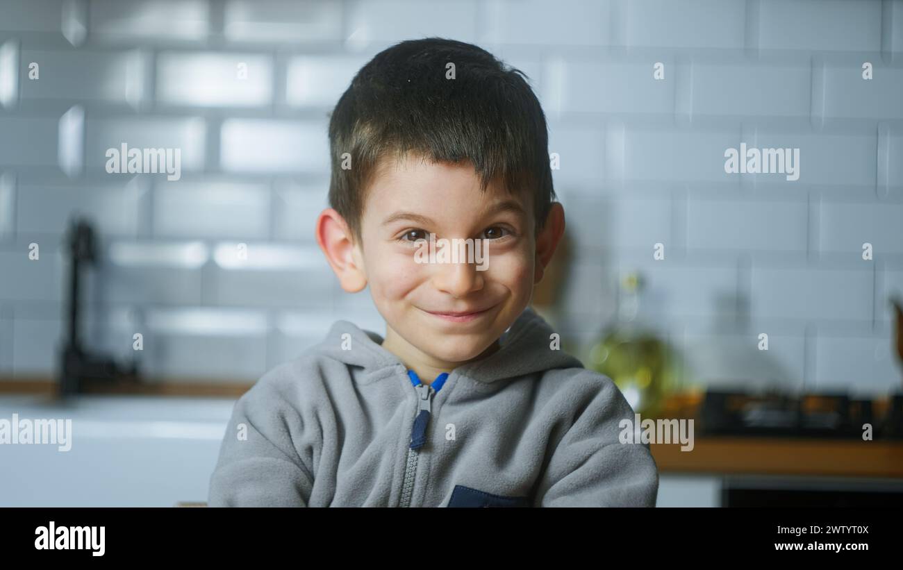 Nahporträt eines süßen kleinen Jungen, der die Kamera lächelnd ansieht und lustige Imitationen macht. Stockfoto