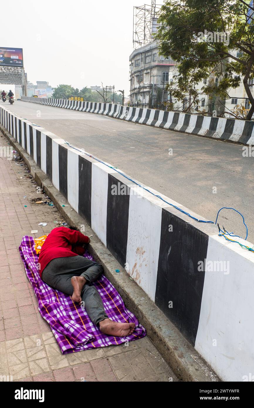 Obdachloser Indianer, der auf dem Bürgersteig in Guwahati, Assam, Indien schläft Stockfoto