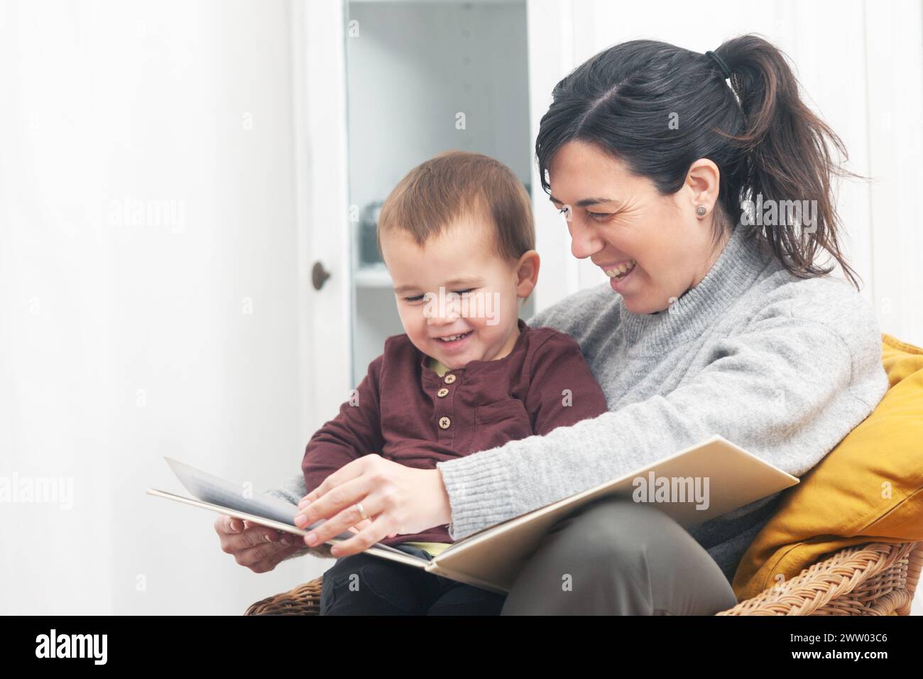 Mutter und Kind genießen einen süßen Moment beim Lesen einer Kindergeschichte mit einem großen Lächeln im Gesicht. Kopierbereich. Stockfoto