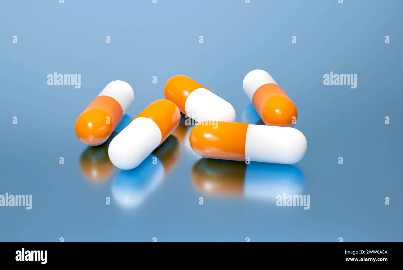 Orangene Heilpillen auf einem reflektierenden Tisch. Orangenkapseln, medizinische Pillen auf einem reflektierenden Tisch. Industrielle Herstellung von Medizin, Antibiotika oder anderen Stockfoto