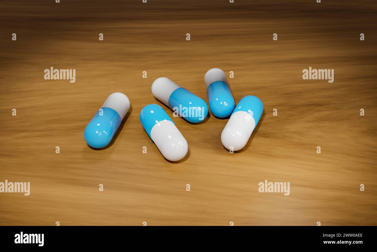 Blaue medizinische Pillen auf einem Holztisch. Blaue Kapseln, medizinische Pillen auf einem Holztisch. Industrielle Herstellung von Medikamenten, Antibiotika oder anderen Medikamenten. S Stockfoto