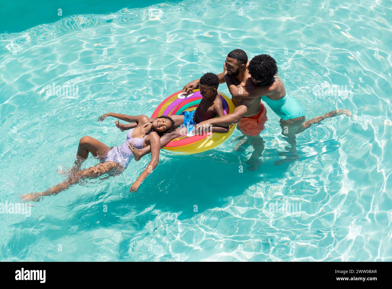 Eine afroamerikanische Familie genießt einen sonnigen Tag im Pool Stockfoto