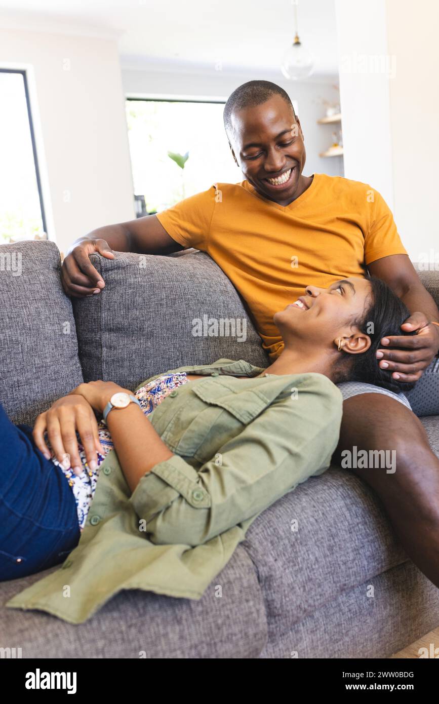 Ein vielseitiges Paar genießt einen entspannten Moment auf dem Sofa zu Hause Stockfoto