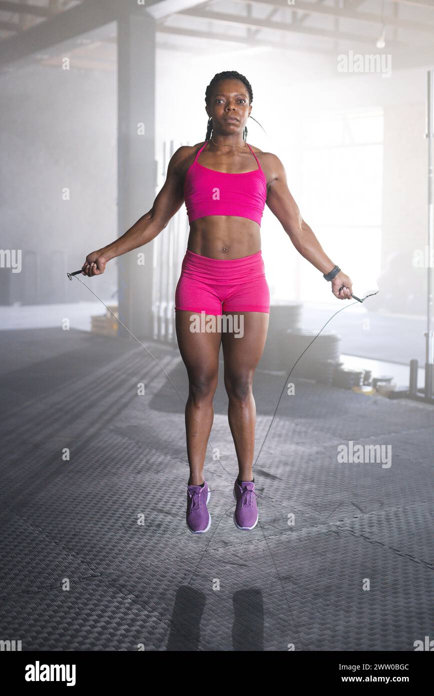 Eine gute afroamerikanische starke Frau springt im Fitnessstudio Stockfoto