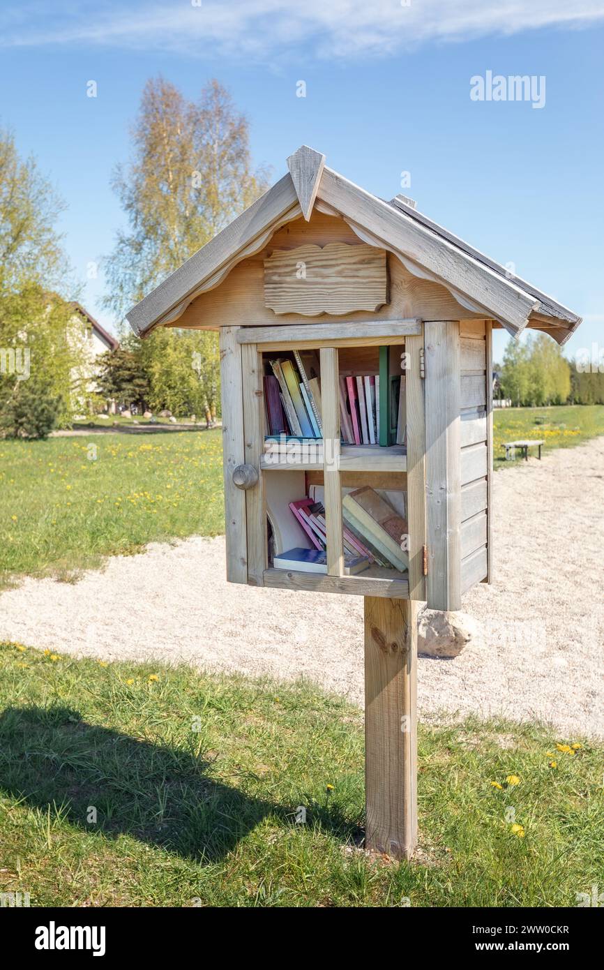 Kleines, hausgemachtes Holzhaus im Stadtpark, in dem die Bürger Bücher kostenlos mitnehmen oder hinterlassen können. Das zweite Leben der Bücher. Stockfoto