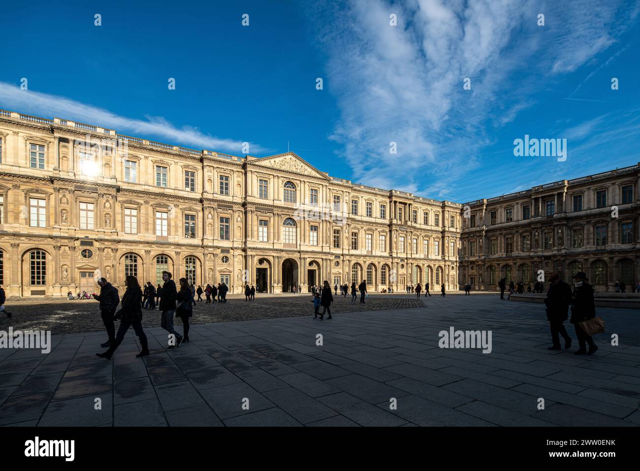 Besucher, die an klaren Tagen durch den Nordflügel des Louvre schlendern. Stockfoto