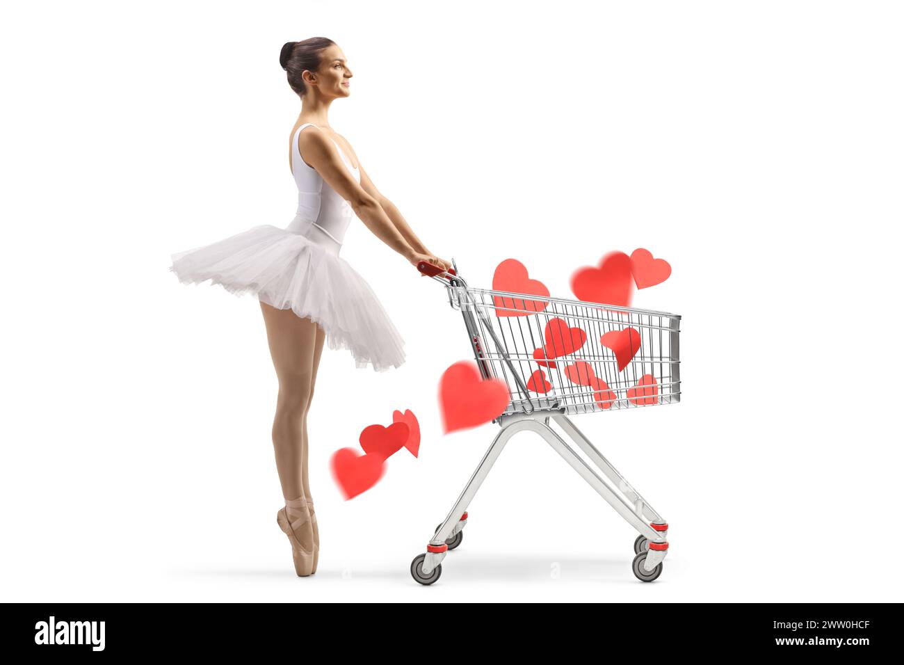 Profilaufnahme einer Ballerina in voller Länge, die mit einem Einkaufswagen voller roter Herzen auf weißem Hintergrund wartet Stockfoto
